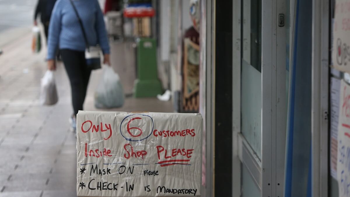 悉尼一家商店门上的牌子上写着：店内请只有6名顾客，请戴上口罩，必须办理入住手续